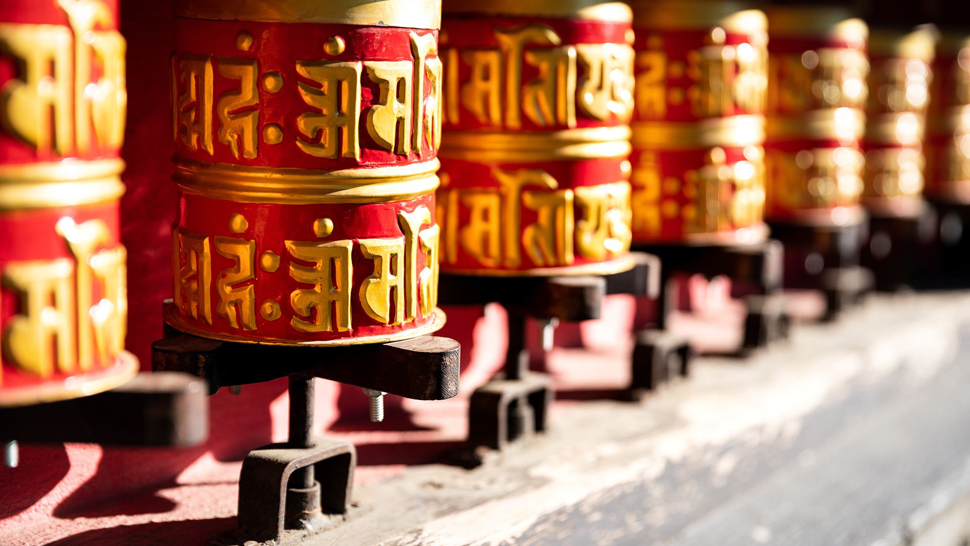 Rows of red and gold prayer wheels in Manang